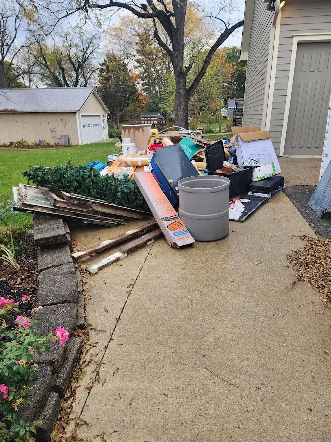 Dumpster being loaded with debris for Estate Cleanout Dumpster Rental in East Bloomfield
